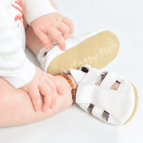 Baby wearing white Dotty Fish barefoot sandals.