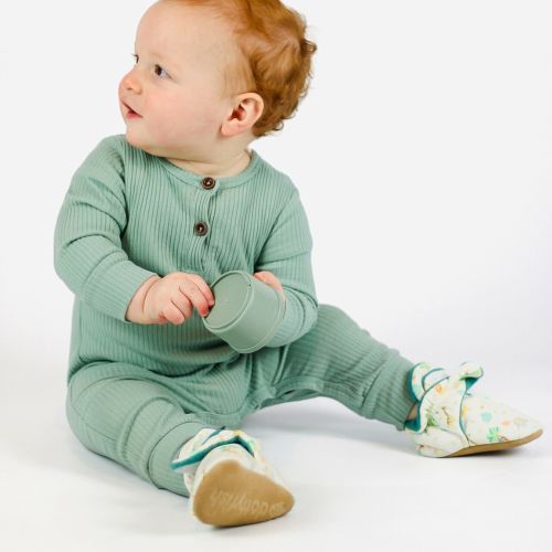 Toddler wearing cotton booties in safari design.