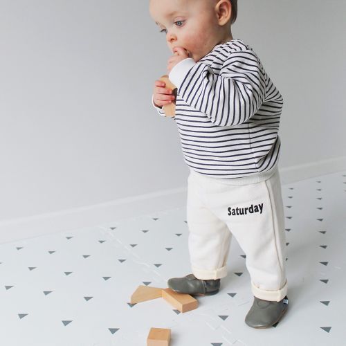 Toddler standing, wearing plain grey leather shoes from Dotty Fish.