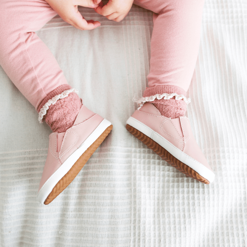 Little girl wearing Dotty Fish pink leather pre-walker rubber sole slip-on shoes.