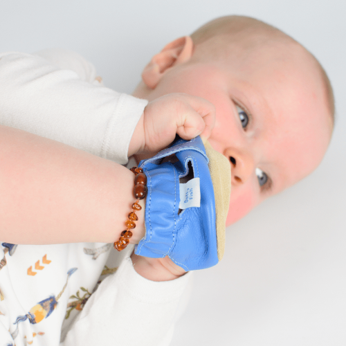Baby boy, wearing blue leather Dotty Fish first walker barefoot sandals.