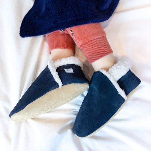 Toddler wearing Dotty Fish navy suede slippers.