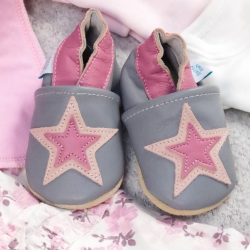 Grey and pink leather shoes in drawer with baby clothing.