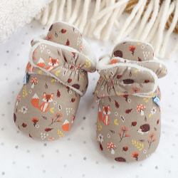 Woodland baby booties, sitting on baby blankets.