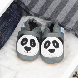 Grey leather shoes with panda design, in drawer with baby clothing.