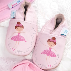 Pink leather ballerina shoes in drawer with baby clothing.