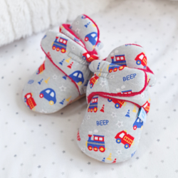 Dotty Fish vehicles baby booties, sitting on baby blanket.